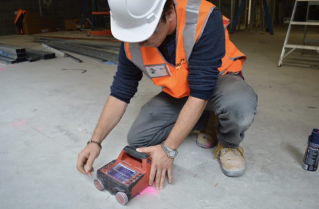 A technician performing concrete scanning services using advanced ground-penetrating radar (GPR) to detect embedded rebar, post-tension cables, and utilities before core cutting or demolition work in Dubai. This ensures safe and precise drilling without damaging the surrounding structure.