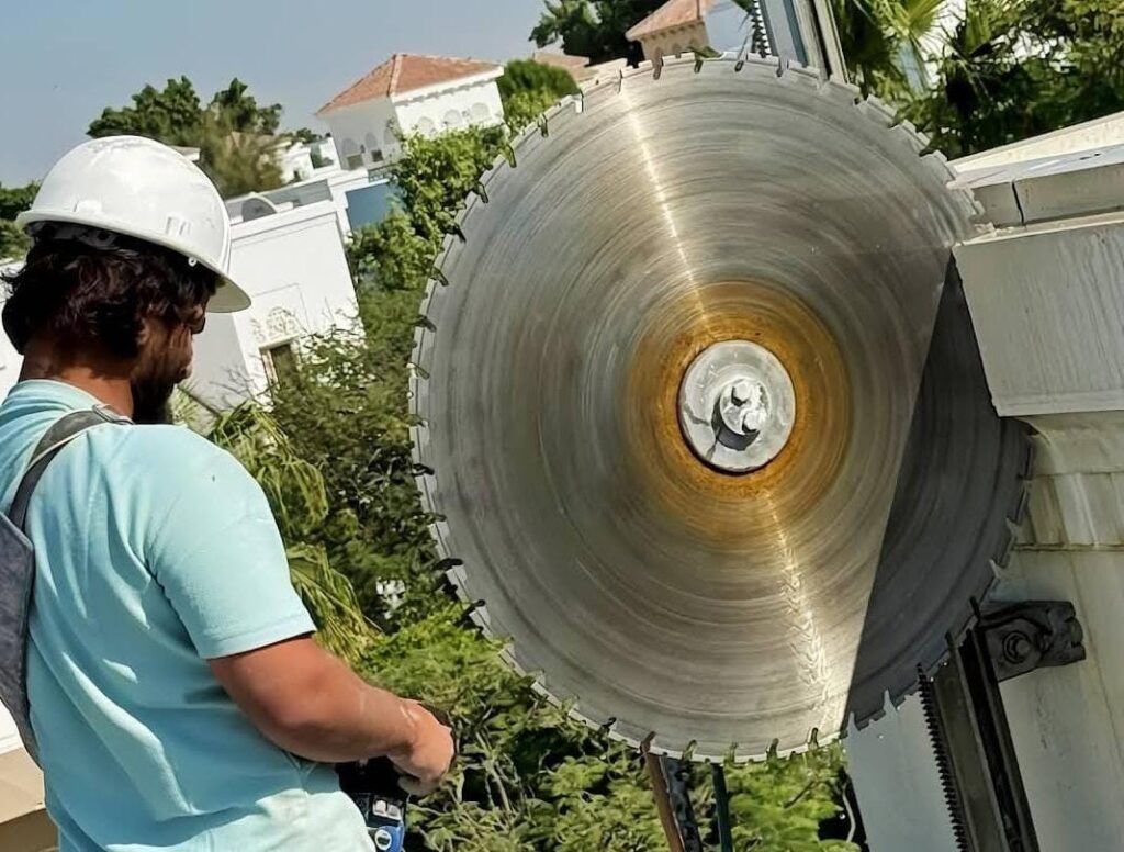 Concrete cutting machine slicing concrete wall at construction site in United Arab Emirates