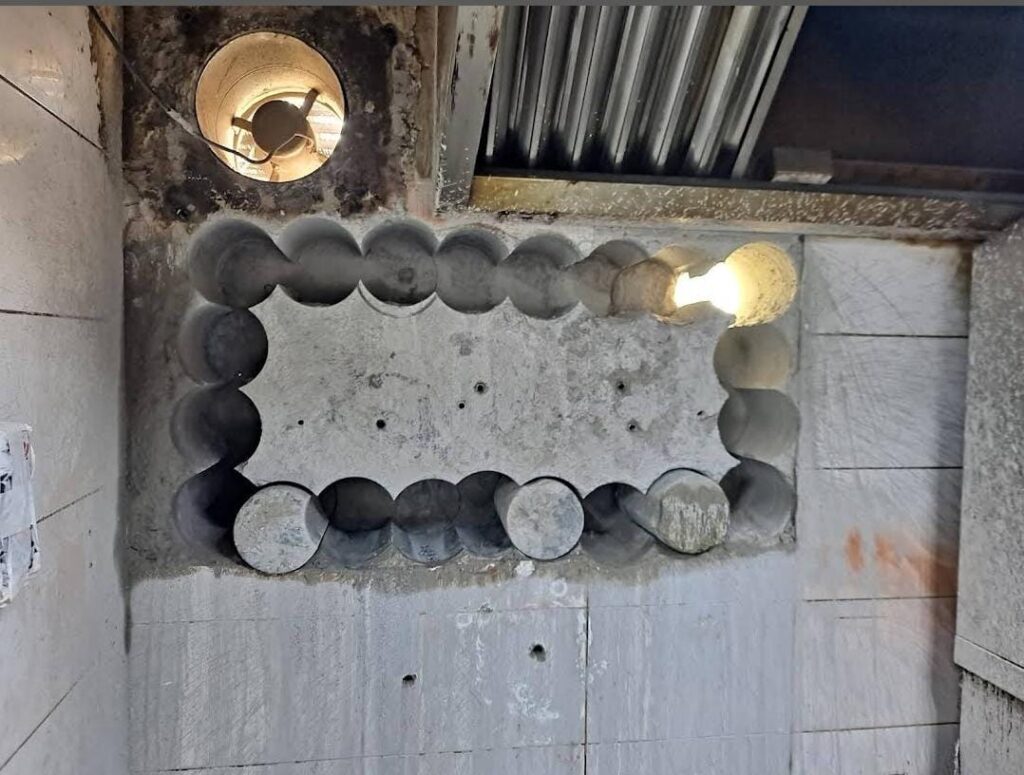 Wall cutting machine creating opening in concrete wall at construction site in United Arab Emirates