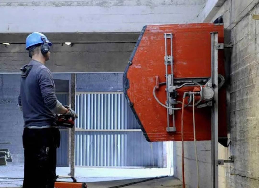 Wall saw cutting machine cutting reinforced concrete wall at construction site in United Arab Emirates